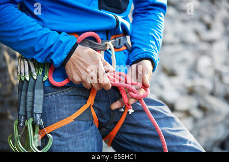 Kletterer befestigen eine acht Knoten auf seine Kletterseil, Martinswand Klettern, Zirl, Tirol, Österreich Stockfoto