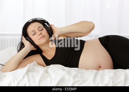 Schwangere Frau Musik hören Stockfoto