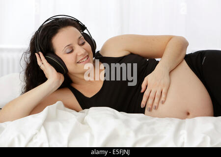 Schwangere Frau Musik hören Stockfoto