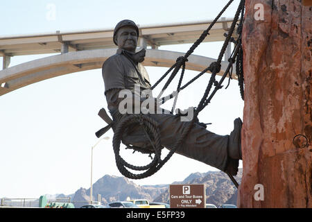 Statue von dam Arbeitnehmer Klippe am Hoover-Staudamm, Nevada mit Mike O' Callaghan-Pat Tillman Memorial Bridge hinter hängen. Stockfoto