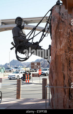 Statue von dam Arbeitnehmer Klippe am Hoover-Staudamm, Nevada mit Mike O' Callaghan-Pat Tillman Memorial Bridge hinter hängen. Stockfoto