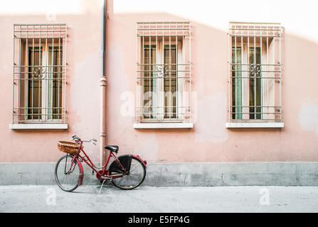 Roten alten italienischen Fahrrad auf Sonnenlicht. Alte Gebäude Stockfoto