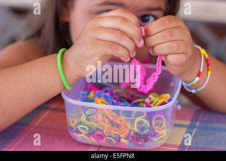 Mädchen schaffen machen Armband bunte "loom Bands" Hände Porträt Closeup Hobby-Handwerk Stockfoto