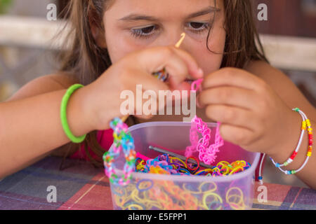 Mädchen schaffen machen Armband bunte "loom Bands" Hände Porträt Closeup Hobby-Handwerk Stockfoto