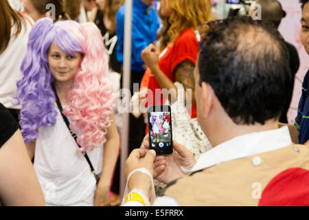 LONDON, ENGLAND Mann fotografiert junge weibliche Cosplayer bei Hyper Japan in Earls Court. Stockfoto