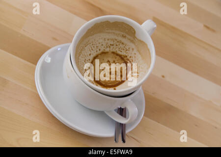 Zwei gestapelte leere Tassen Kaffee auf einem Holztisch Stockfoto