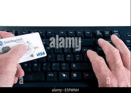 Mann hält Kreditkarte und auf einer Computertastatur eingeben. Stockfoto