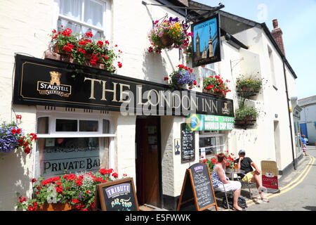 Eine Cornish "Pub mit hängenden Körbe, roten Blüten und ein 'London Inn'-Zeichen. Stockfoto