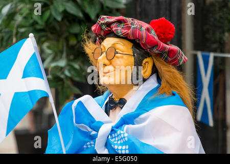 Kleine Puppe von einem Mann gekleidet in ein Tartan Hut, bedeckt mit einer Saltire-Fahne und tragen eine kleine Flagge, Stockfoto