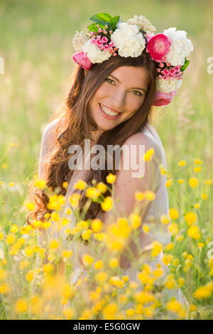 Frau mit Blumen Kranz auf einer Wiese Stockfoto