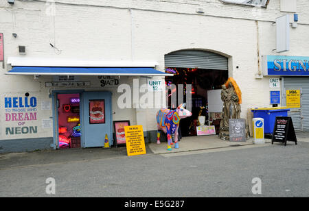 Götter eigenen Schrottplatz Neon Beleuchtung Shop neben der rollenden Scone Cafe mit bunten Kuh vor Walthamstow, London Borough Stockfoto