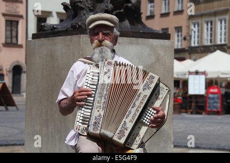 Akkordeonist in der Warschauer Altstadt spielen neben der berühmten Statue der Meerjungfrau Stockfoto