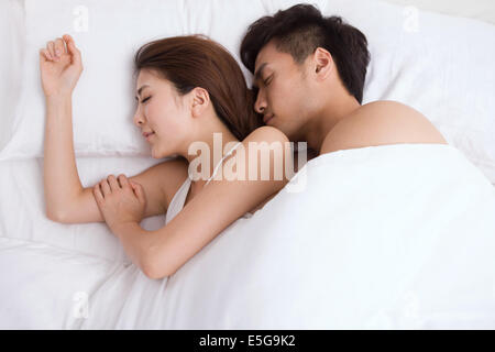 Junges Paar auf Bett liegend Stockfoto