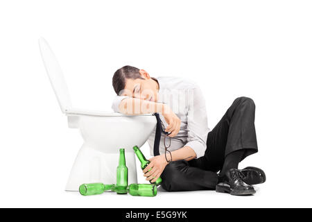 Männlicher Alkoholiker schlafen auf einer Toilette Stockfoto