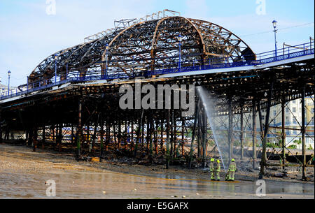 Eastbourne, Sussex, UK. 31. Juli 2014.Fire Dienstleistungen dämpfen hinunter die verschlungenen Wrack von Eastbourne Pier heute Morgen am Tag nach der vordere Bereich durch zerstört wurde Feuer Feuerwehr kämpften das Feuer gestern Nachmittag und Abend, nachdem die Frontpartie Brand Credit gefangen: Simon Dack/Alamy Live News Stockfoto