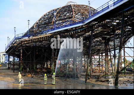 Eastbourne, Sussex, UK. 31. Juli 2014.Fire Dienstleistungen dämpfen hinunter die verschlungenen Wrack von Eastbourne Pier heute Morgen am Tag nach der vordere Bereich durch zerstört wurde Feuer Feuerwehr kämpften das Feuer gestern Nachmittag und Abend, nachdem die Frontpartie Brand Credit gefangen: Simon Dack/Alamy Live News Stockfoto