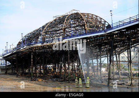 Eastbourne, Sussex, UK. 31. Juli 2014.Fire Dienstleistungen dämpfen hinunter die verschlungenen Wrack von Eastbourne Pier heute Morgen am Tag nach der vordere Bereich durch zerstört wurde Feuer Feuerwehr kämpften das Feuer gestern Nachmittag und Abend, nachdem die Frontpartie Brand Credit gefangen: Simon Dack/Alamy Live News Stockfoto