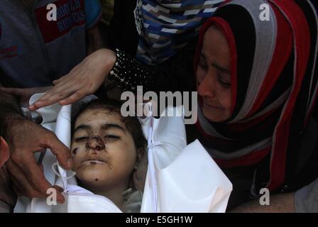 Gaza. 31. Juli 2014. Israelischen Luftangriff auf einem Marktplatz in Al-Schadschaija Nachbarschaft. 31. Juli 2014. Ein Verwandter von palästinensisches Mädchen Layan al-Seide, die Sanitäter bei einem israelischen Luftangriff auf einem Marktplatz in Al-Schadschaija Nachbarschaft getötet wurden sagte, trauert neben ihrem Körper während ihrer Beerdigung in Gaza-Stadt am 31. Juli 2014. Rund 17 israelische Artillerie-Granaten schlug auf dem Markt Mittwoch, 17 Palästinenser getötet und verletzt mehr als 170 Personen, Sanitäter und Zeugen sagte. Bildnachweis: Yasser Qudih/Xinhua/Alamy Live-Nachrichten Stockfoto