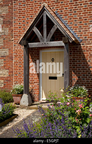 Vordere Veranda und Tor des englischen Bauernhaus mit Pfad und Cottage Garten Stockfoto