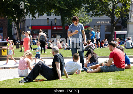 Menschen, die zu Mittag genießen heißen Sommertag auf dem Gelände der Belfast City Hall im Zentrum Stadt Stockfoto