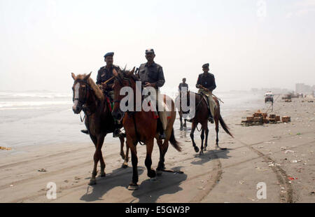 Karachi, Pakistan. 31. Juli 2014. Polizeibeamte nehmen Stellung und wiederherstellen Stab über den Menschen Besuch Sea View Beach Clifton trotz eines Verbots nach dem Schwimmen im Meer, in Karachi auf Donnerstag, 31. Juli 2014 in Rechnung gestellt. Am Mittwoch mehr als Dutzend Personen am Clifton Beach ertrunken, stieg die Zahl der Ertrunkenen Personen zu neunzehn seit Mittwoch Abend am zweiten Tag des Eid-Ul-Fitar. Drei der Opfer waren Mitglieder der gleichen Familie und ihren Körper wieder in ihre angestammten Bereich gesendet wurden. Bildnachweis: Asianet-Pakistan/Alamy Live-Nachrichten Stockfoto