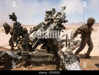 U.S. Marine Lance Cpl. Samuel Travis, Recht, zugewiesen 5. Bataillon, 14. Marinen, zieht die Kordel um die M777 Lightw Feuer Stockfoto