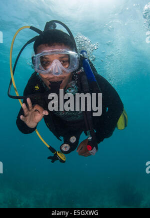 Belize Defense Force Petty Officer 3rd Class Abraham Hinds signalisiert den Blei-Taucher während eines Tauchgangs Training mit US-Segler Assi Stockfoto