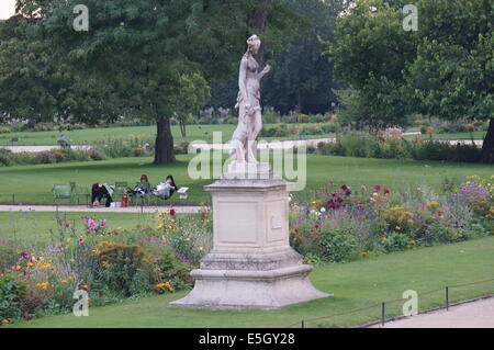 Eine Skulptur, Blumenbeete, Menschen entspannen in den Stühlen im Jardin des Tuileries Garden Stockfoto
