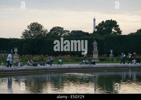 Jardin des Tuileries Garden spiegelt sich im Teich dekoriert mit Blumenbeeten Menschen entspannen in den Stühlen Eiffelturm im Hintergrund Stockfoto