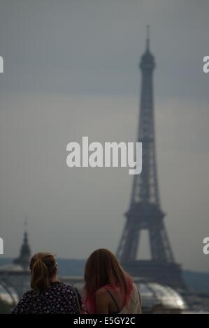 Rückansicht der zwei Frauen auf der Suche auf dem entfernten Eiffelturm von einer Panorama-Terrasse auf der Oberseite des Printemps Paris speichern Stockfoto