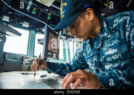 US Navy Quartiermeister 2. Klasse Jacques Chenet, zugeordnet der Lenkwaffenzerstörer USS Kidd (DDG-100), steht die Uhr auf Stockfoto