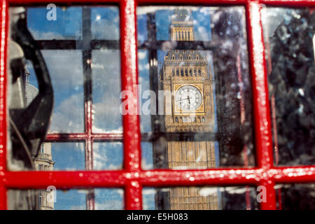 Big Ben Clock Tower von den Houses of Parliament, gesehen durch die Fenster der traditionelle rote Telefonzelle London England UK Stockfoto