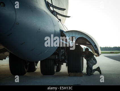 Ein US Air Force Pilot inspiziert das Fahrwerk eines Flugzeugs c-17 Globemaster III, 1. Juli 2014, auf dem Flug Linie am Gelenk Stockfoto