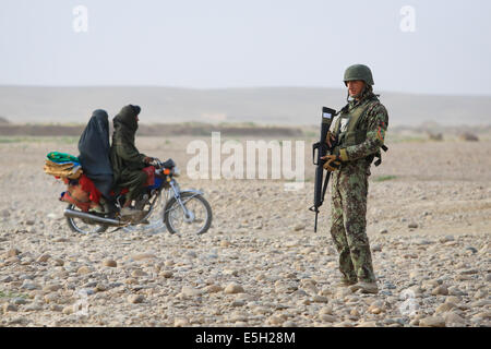 Afghanische Zivilisten fahren Sie vorbei ein Afghan National Army-Soldat mit dem 4. Tolay, 6. Kandak, 6. Brigade, 215. Korps als He provi Stockfoto