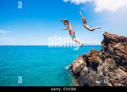 Freunde-Klippen springen ins Meer, Sommerspaß Lebensstil. Stockfoto