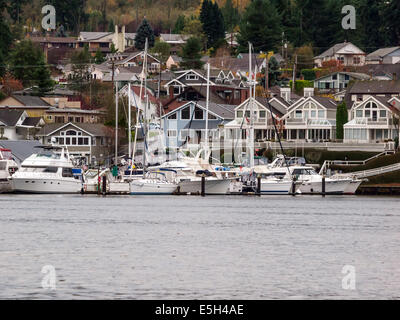 Bild der Segelboote und Motorboote angedockt in einer Marina in Gig Harbor, Washington, mit Häusern auf Hügel im Hintergrund. Stockfoto