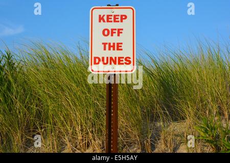 Ein Schild Warnung warnt die Menschen, aus den Dünen zu bleiben, die den Strand schützen. Stockfoto