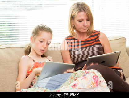 Mutter und junge Tochter mit Apple iPads zusammen Stockfoto
