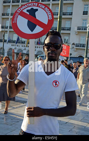 Athen, Griechenland. 31. Juli 2014. Ein Einwanderer hält eine Anti Krieg Streikposten dabei die 'V'-Zeichen. Linke Partei Anhänger zusammen mit Menschen aus Palästina organisiert eine Demonstration in Athen zur Unterstützung des Staates Palästina fordert den Stopp des Blutvergießens. (Poto von George Panagakis/Pacific Press/Alamy Live-Nachrichten) Stockfoto