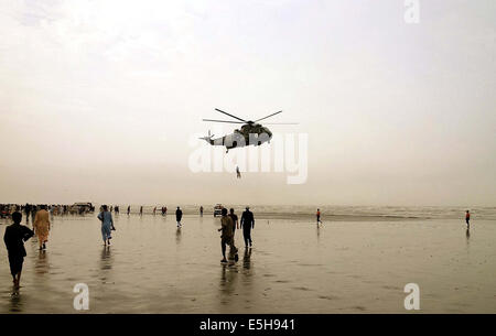 Karachi. 31. Juli 2014. Ein Pakistan Marine Sea King Hubschrauber ist mit einem Froschmann, befestigt an einer Winde aus dem Flugzeug transportiert einen wiederhergestellten Körper ein ertrinkendes Opfer über Clifton Beach im südlichen Hafenstadt pakistanischen Stadt Karachi am 31. Juli 2014. Die Leichen von acht Menschen, die beim Baden im Meer in der Nähe von Pakistans südlichen Hafen Stadt Karachi am Mittwoch vermisst, am Donnerstag durch die Rettungskräfte geborgen wurden, berichtet die Zahl der Todesopfer auf 20, lokale Medien zu bringen. © Masroor/Xinhua/Alamy Live-Nachrichten Stockfoto