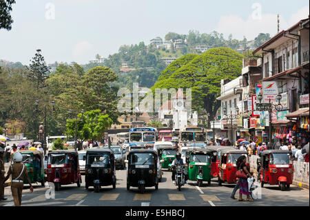Menschen Fuß über die Hauptstraße, Tuk-Tuks warten in einer Reihe, Kandy, Sri Lanka Stockfoto