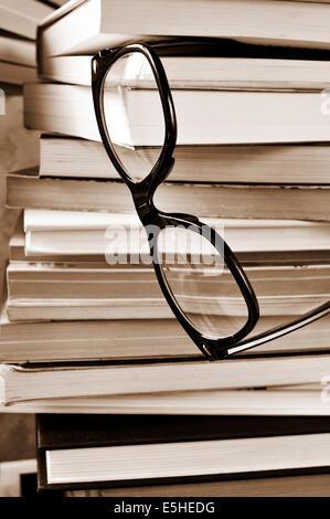 eine Brille auf einen Stapel Bücher in schwarz / weiß Stockfoto