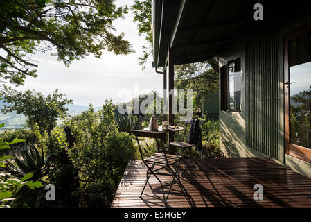 Frühstücks-Tisch und Stühle auf Hügel mit Hacienda außen Spioenkop, Kwa Zulu Natal, Südafrika Stockfoto