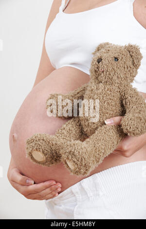 Schwangere Frau mit Teddy Bären hautnah Stockfoto