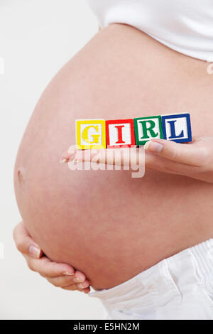 Schwangere Frau mit Blöcken Rechtschreibung Mädchen Nahaufnahme Stockfoto