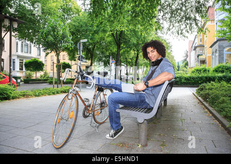 Porträt des jungen männlichen Studenten mit dem Fahrrad in die Stadt Stockfoto