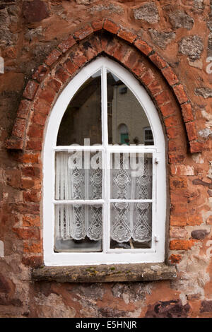 Großbritannien, England, Somerset, Nether Stowey, Lime Street, Spitzevorhang an alten Turnpike Straße Maut Haus Fenster Stockfoto