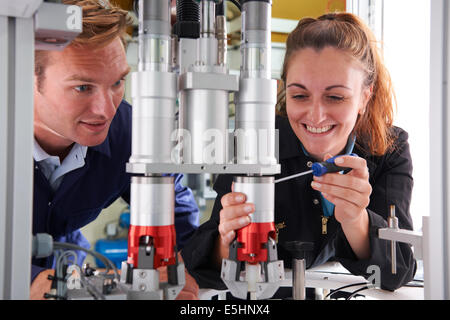 Ingenieur und Lehrling arbeiten an Maschine im Werk Stockfoto