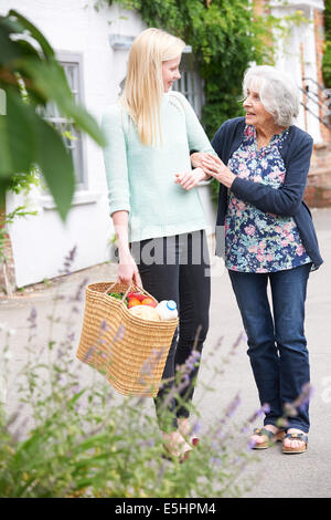 Teenager-Mädchen hilft Senior Frau einkaufen durchzuführen Stockfoto