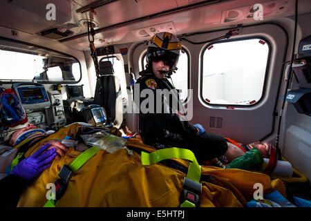 Trooper Michael McCloskey, Maryland State Police Flug Medic, spricht mit seinem Partner während einer MedEvac-Mission, 16. Juni 2014 in Stockfoto